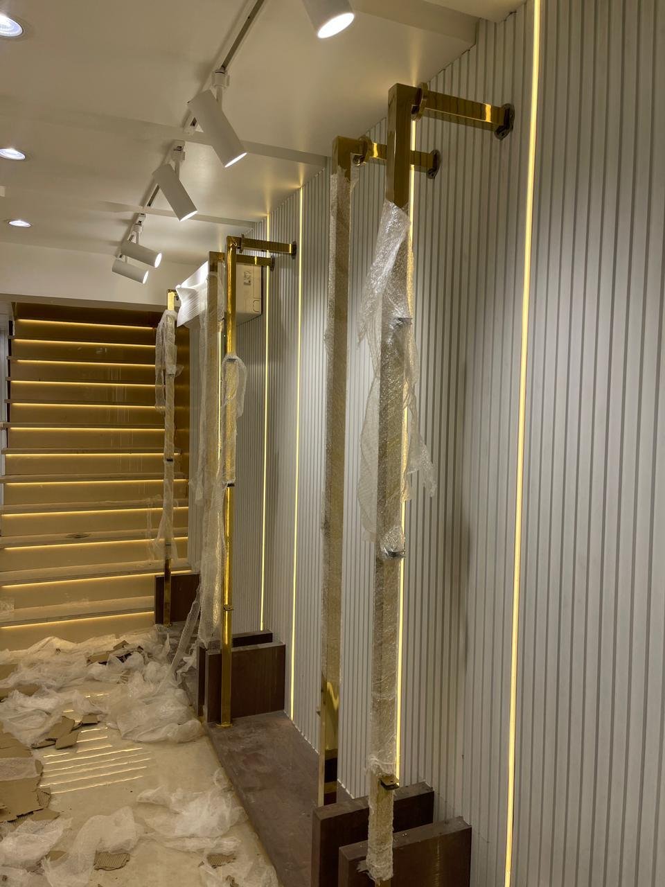 Retail boutique with fluted LED-lit walls and gold fixtures